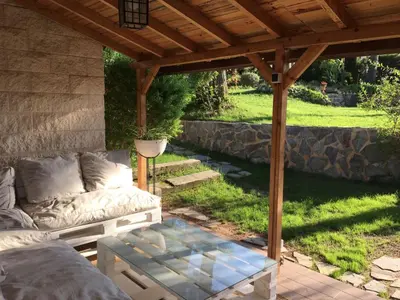 a patio with a couch under a wooden pergola at Domus Valencia Apartamentos Casa con piscina privada a 30 minutos de Valencia in Turís
