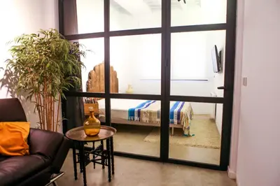 a living room with a couch and a bed through a window at Apartment Triador in Valencia