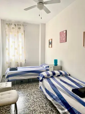 a bedroom with two beds and a ceiling fan at Piso en la playa in Valencia
