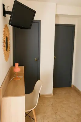 a room with two black doors and a chair at Rooms Avenida in Tavernes de Valldigna