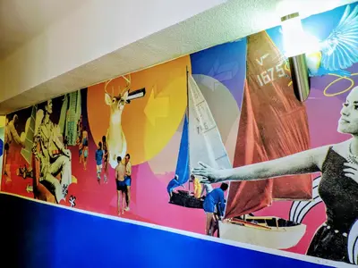 a woman is pointing at a mural on a wall at Feetup Home Backpackers Valencia in Valencia