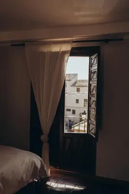 a bedroom with a window with a view of a building at Hotel Restaurante Doña Anita in Requena