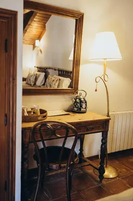a room with a desk with a lamp and a mirror at Hotel Restaurante Doña Anita in Requena