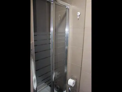 a shower with a glass door and a roll of toilet paper at Apartment Sofi in Valencia