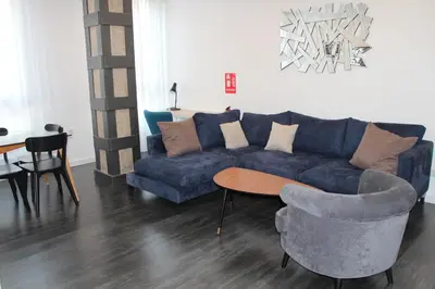 a living room with a blue couch and a table and chairs at Apartment Sofi in Valencia