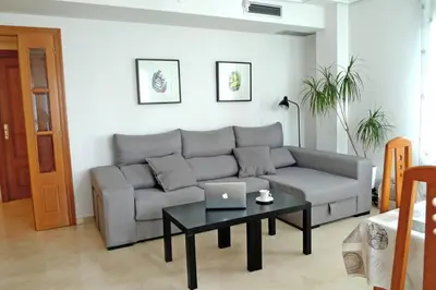 a living room with a couch and a table with a laptop at Apartamento en la Ciudad de las ciencias in Valencia