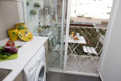 a kitchen with a washing machine and a balcony at Antiguo Reino Apartment in Valencia