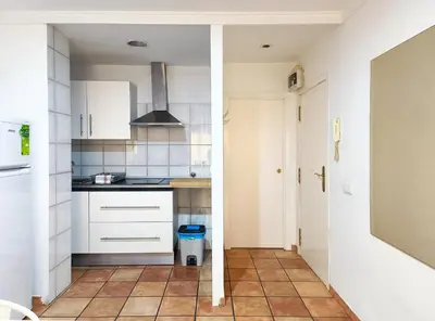 a kitchen with white cabinets and a tile floor at Flats Friends Nave in Valencia