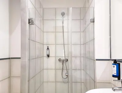 a shower in a bathroom with white tile at Flats Friends Nave in Valencia