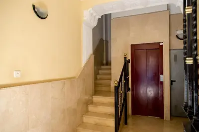 a hallway with stairs and a wooden door at MD Oliag in Valencia
