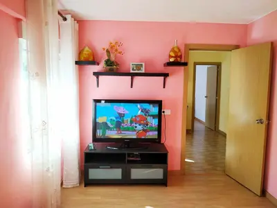 a living room with a tv and a pink wall at Apartamento Turistico en Valencia in Valencia