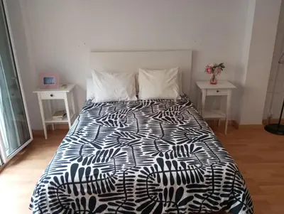 a bedroom with a black and white bed with two tables at Santos Studio 2 in Valencia