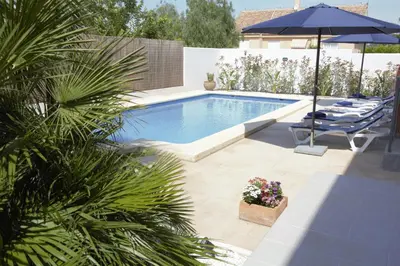 a swimming pool with chairs and an umbrella at Hotel Vista al Sol in Paterna