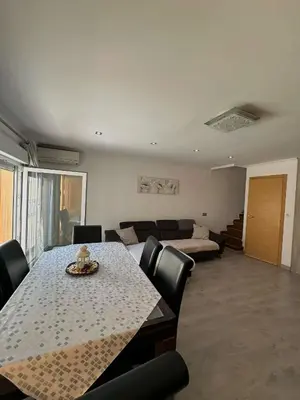 a living room with a table and a couch at Dúplex, piscina y playa in Puebla de Farnals