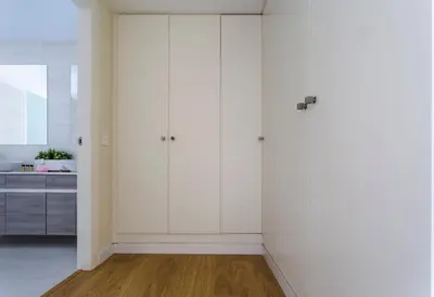 a white kitchen with white cabinets and a wooden floor at HQ Rooms Apartments San Vicente in Valencia