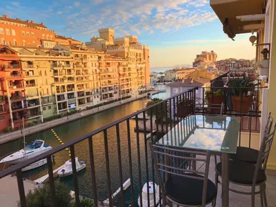 a balcony with a view of a river and buildings at Cozy apartment on the sea in Port Saplaya