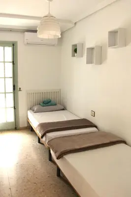 a row of beds in a room with a window at Cozy apartment on the sea in Port Saplaya
