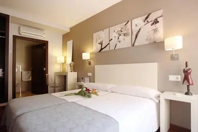 a bedroom with a white bed with flowers on it at Dormavalencia Hostel Regne in Valencia
