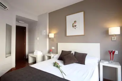 a bedroom with a large white bed with flowers on it at Dormavalencia Hostel Regne in Valencia