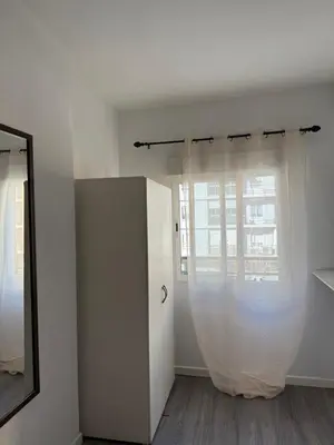 a white room with a mirror and a window at Avenue Rooms in Valencia