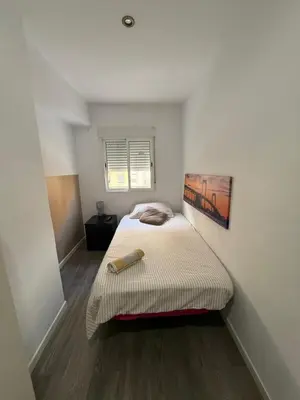 a small bedroom with a bed in the corner at Avenue Rooms in Valencia