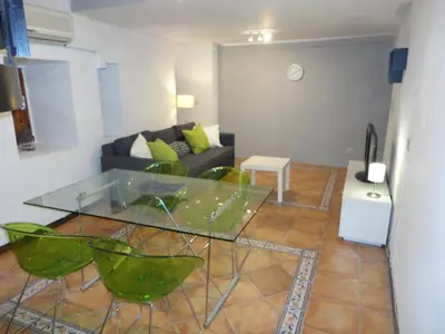 a living room with a glass table and green chairs at Center Valencia in Valencia