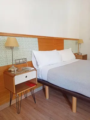 a bedroom with a bed and a table with a lamp at Balcón Al Mar in Valencia