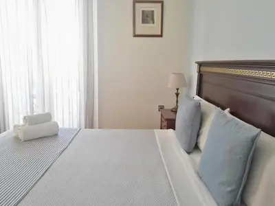 a bedroom with a large white bed with blue pillows at Balcón Al Mar in Valencia