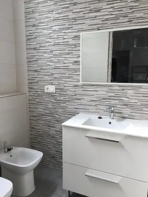 a bathroom with a sink and a toilet and a mirror at Piso céntrico Plaza Toros in Valencia