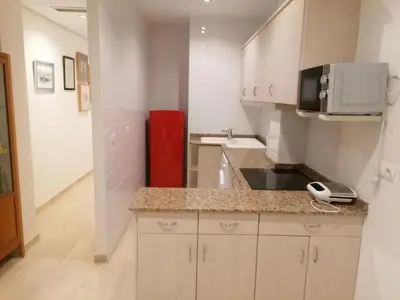 a kitchen with a counter with a microwave and a sink at Apartamento playa Las Arenas in Valencia