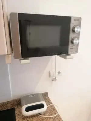 a microwave on top of a kitchen counter with aether at Apartamento playa Las Arenas in Valencia