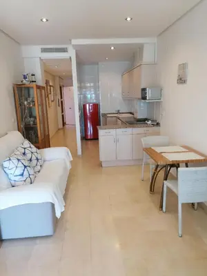 a kitchen and living room with a couch and a table at Apartamento playa Las Arenas in Valencia