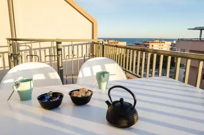 a table with bowls of food on top of a balcony at ApartUP Patacona Attic I in Valencia