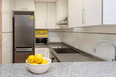 a kitchen with a bowl of fruit on a counter at ApartUP Patacona Attic I in Valencia