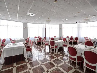 a dining room with white tables and red chairs at Hotel Vila-real Azul in Villareal