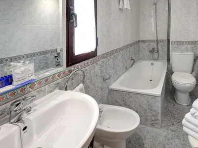 a bathroom with a sink and a toilet and a tub at Hotel Vila-real Azul in Villareal