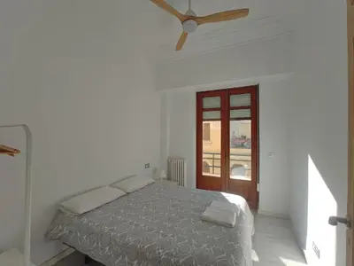 a white bedroom with a bed and a ceiling fan at Entre la Estación y el Ayuntamiento in Valencia