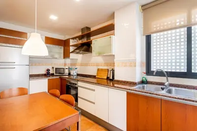 a kitchen with white cabinets and a wooden table at Exclusive Museum in Valencia