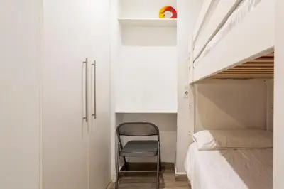 a chair sits next to a bed in a bedroom at APARTAMENTO DE ENSUEÑO in Valencia