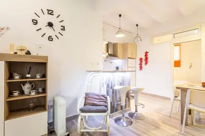 a kitchen with a table and a clock on the wall at APARTAMENTO DE ENSUEÑO in Valencia