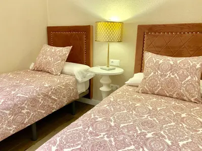 a small bedroom with two beds and a lamp at Hi Valencia Canovas in Valencia