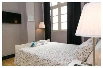 a small bedroom with a bed with a window at Hi Valencia Canovas in Valencia
