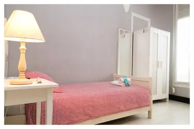 a bedroom with a bed with a lamp and a table at Hi Valencia Canovas in Valencia