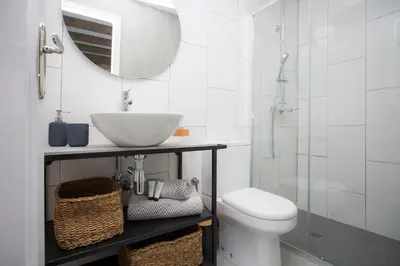 a bathroom with a sink and a toilet and a mirror at SingularStays Parque Central in Valencia