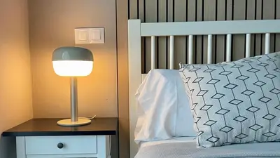 a lamp on a night stand next to a bed at MD Modern Hotel - Jardines in Valencia