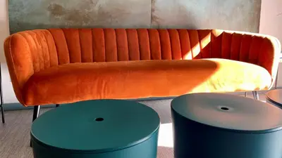 an orange couch with two stools in a room at MD Modern Hotel - Jardines in Valencia