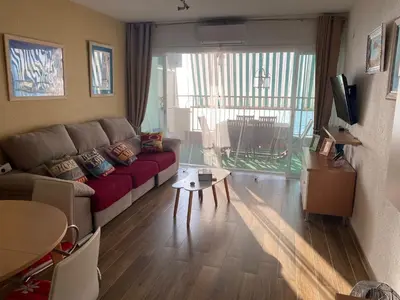 a living room with a couch and a table at Apt. New Holiday Valencia Beach in El Puig