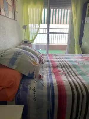 a bedroom with a bed with a colorful comforter at Apt. New Holiday Valencia Beach in El Puig