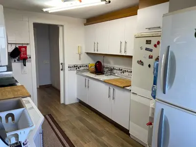 a kitchen with white cabinets and a white refrigerator at Apt. New Holiday Valencia Beach in El Puig