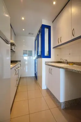 a large kitchen with white cabinets and a sink at Apartamento frente al mar in Valencia